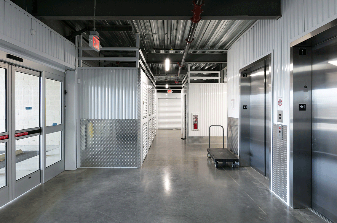Image{width=1137,height=755,url='https://8488932.fs1.hubspotusercontent-na1.net/hubfs/8488932/MesaGallery-4.png',altText='An interior shot of DXD Capital's Mesa self storage facility showing the automatic glass sliding doors in from the left, the freight elevators in from the right and facing a block of 5x5 units.',fileId=null}